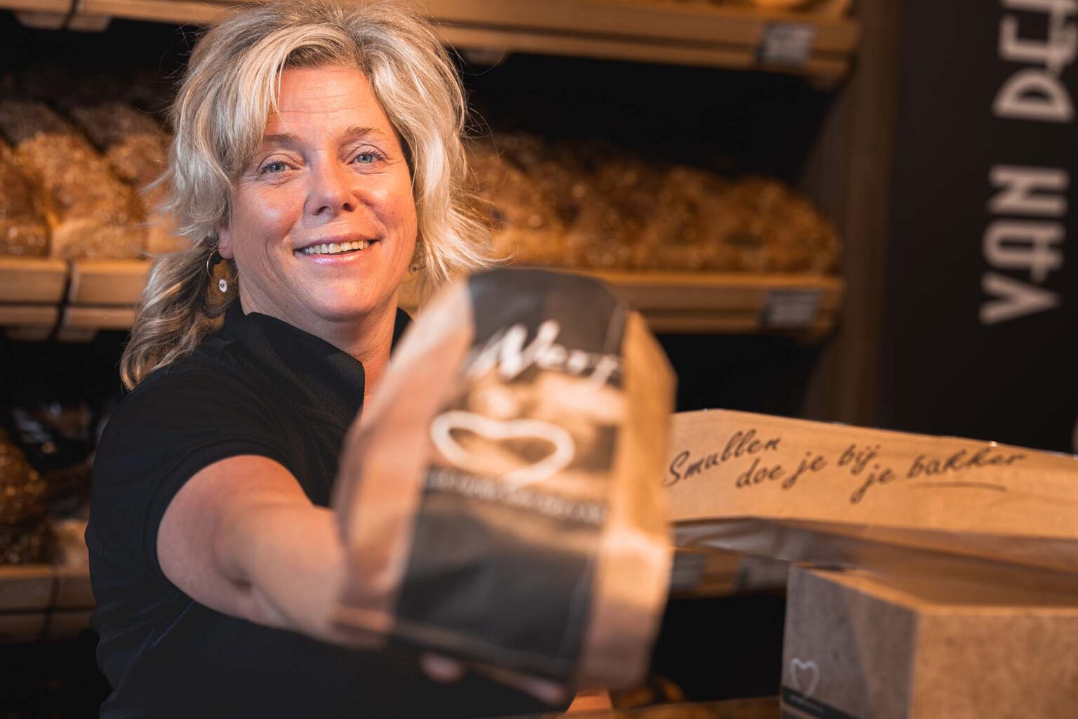 Medewerker van de winkel in Bolsward overhandigd een brood
